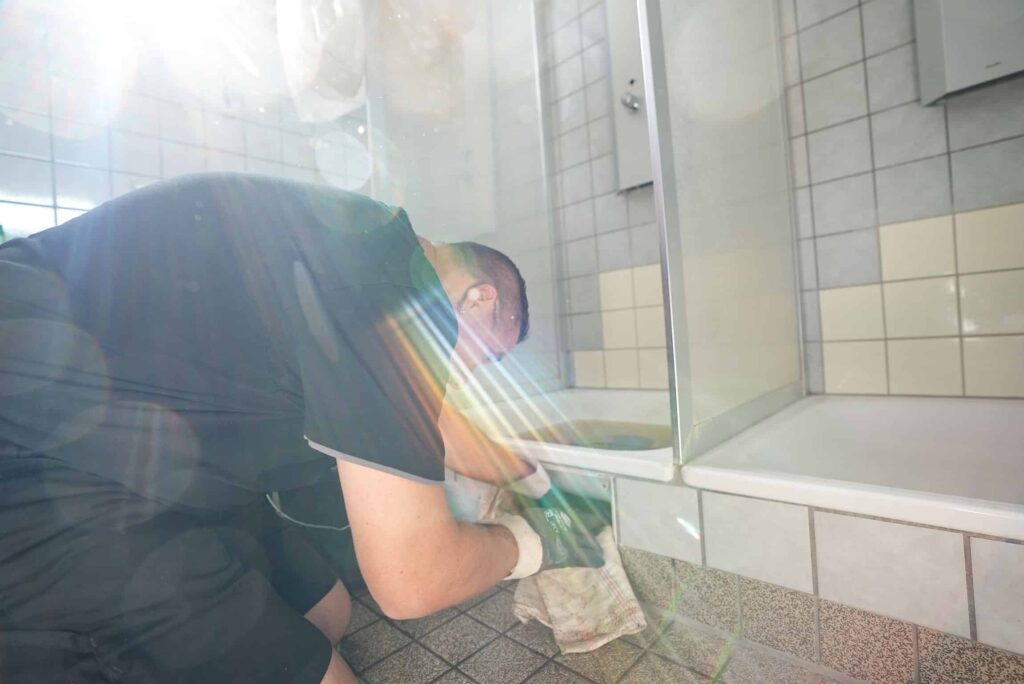 Mitarbeiter repariert Dusche